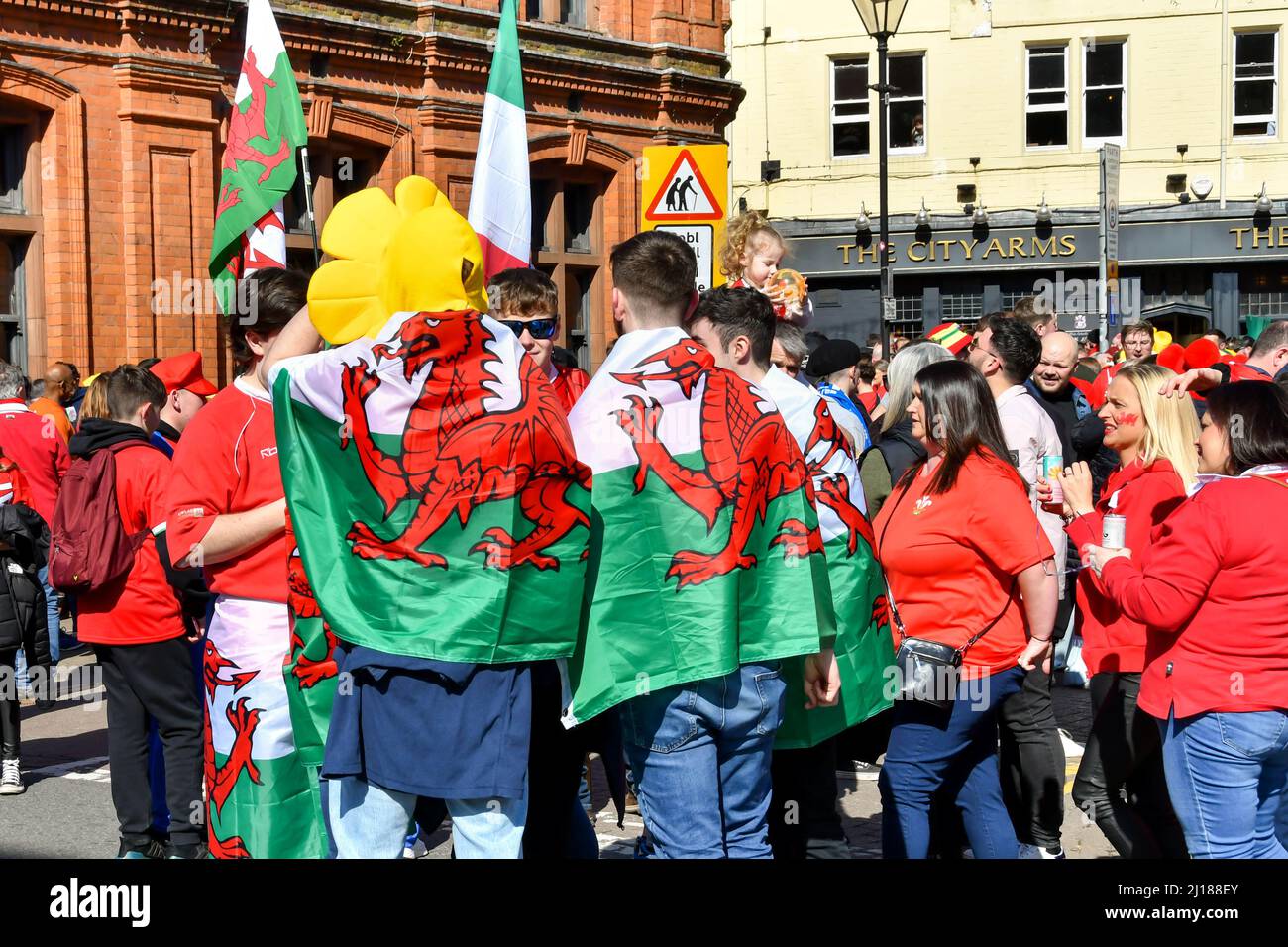 Cardiff, Wales - 2022. März: Rugby-Fans tragen am Spieltag im Stadtzentrum von Cardiff walisische Flaggen um die Schultern Stockfoto