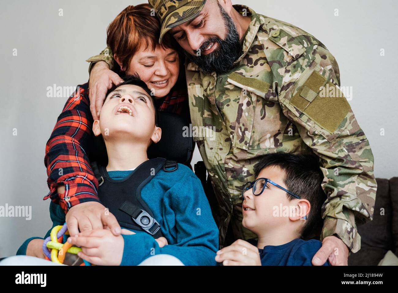 Glücklicher Militärsoldat, der nach der Heimkehr einen zarten Moment mit der Familie hat - Liebe und Kriegskonzepte - Konzentrieren Sie sich auf das Gesicht eines Veteranen Stockfoto