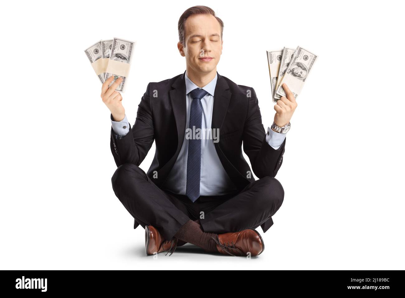 Geschäftsmann meditiert und hält Geld isoliert auf weißem Hintergrund Stockfoto
