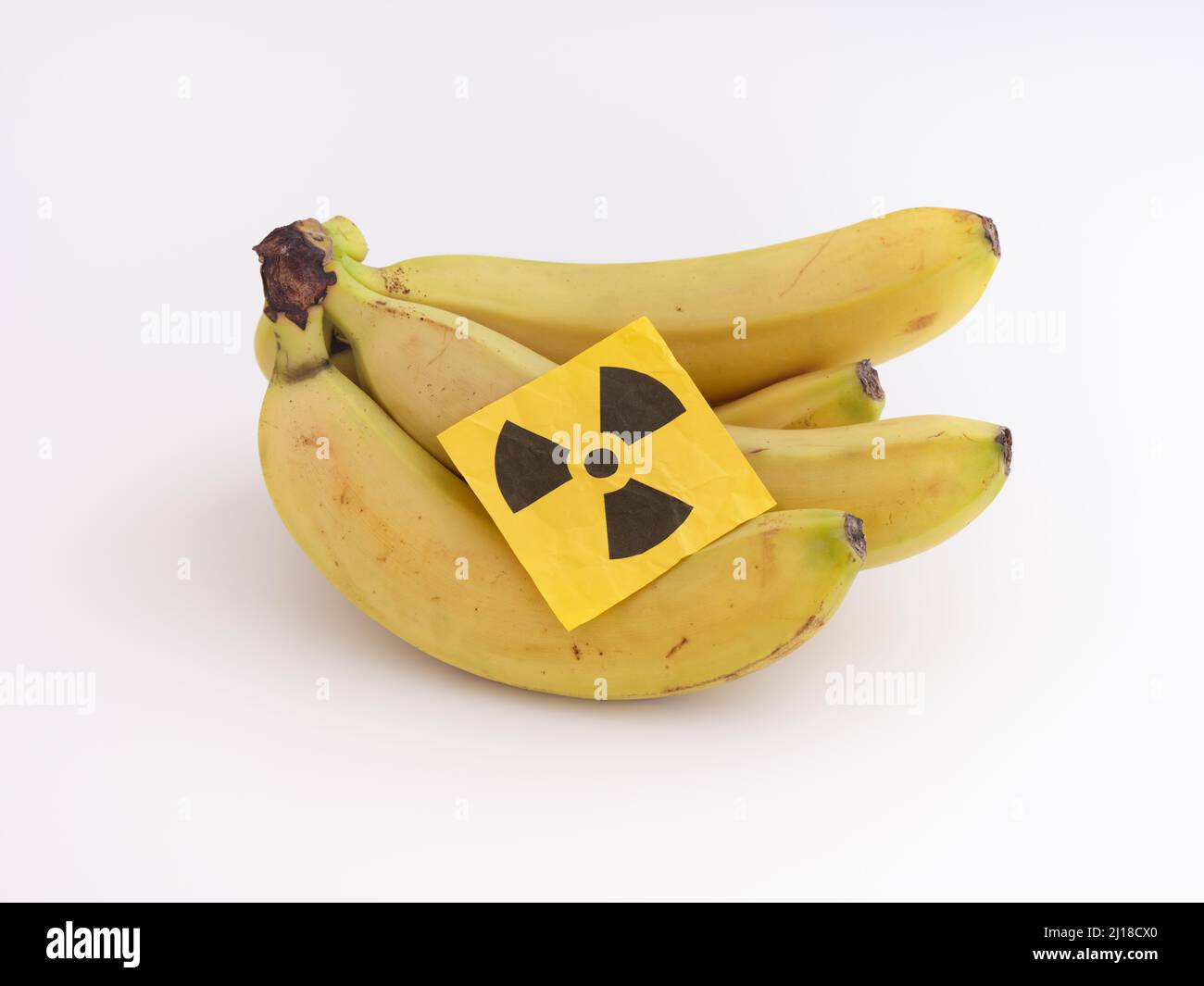 Ein Haufen Bananen mit einem Strahlungswarnschild auf ihnen. Nahaufnahme. Stockfoto
