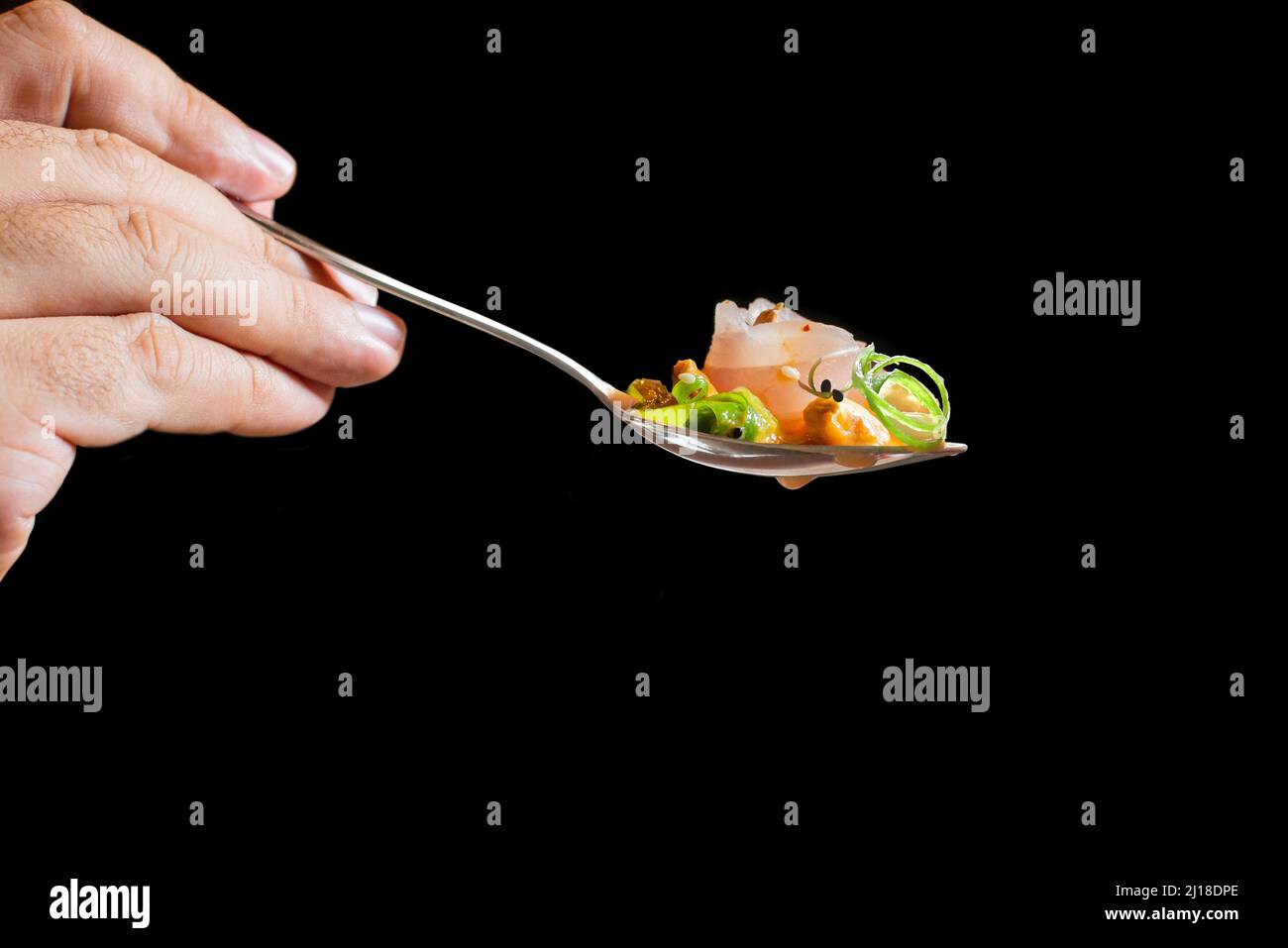 Corvina Ceviche Löffel mit Begleitung auf schwarzem Hintergrund Stockfoto