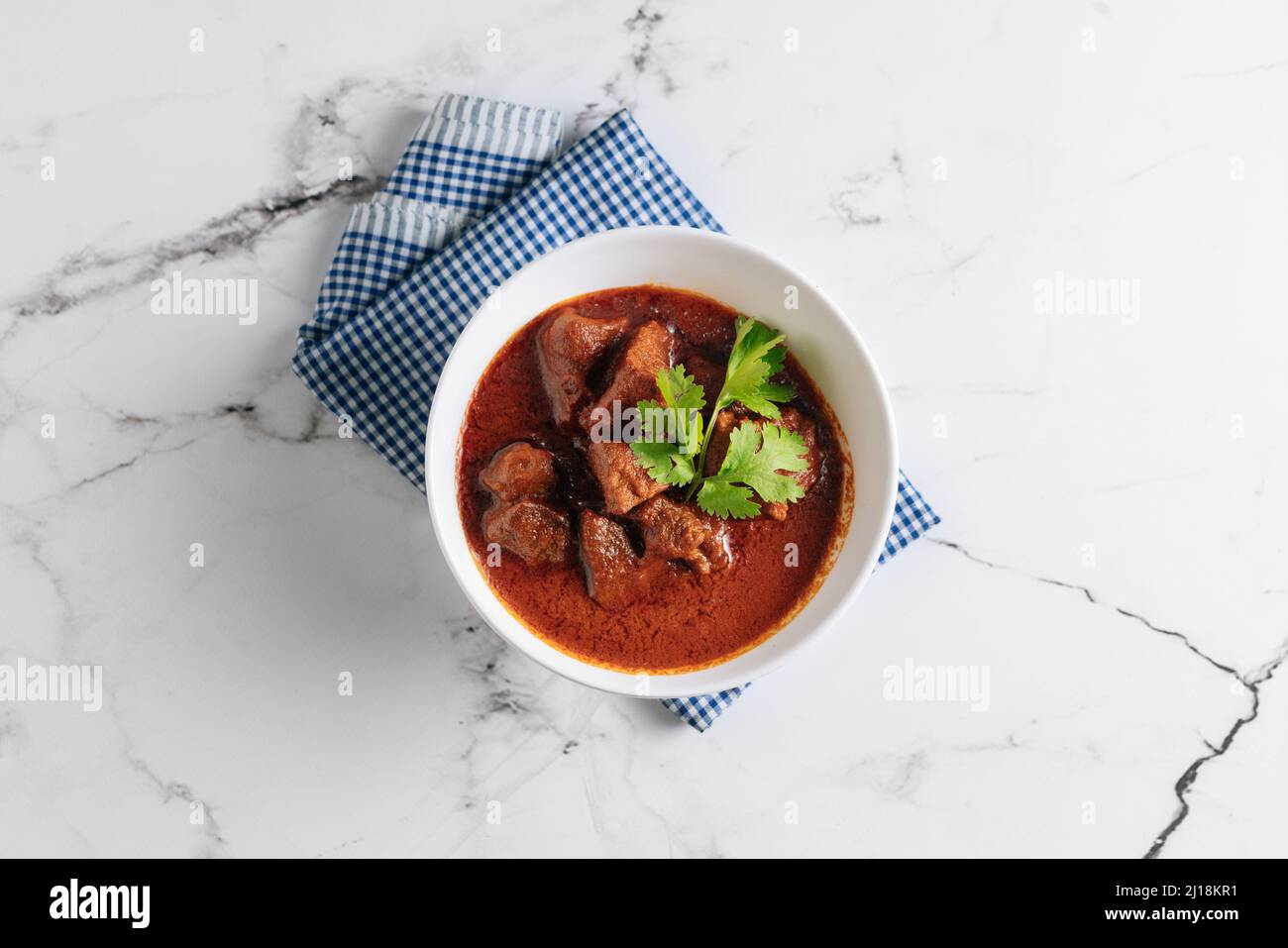 Hammelfleisch Rogan Josh, hammelfleisch Qorma, hammelfleisch-Karahi in einem Gericht isoliert auf Serviette Seitenansicht auf grauem Hintergrund Stockfoto
