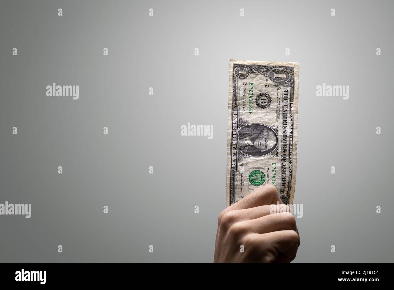 Eine einzelne ein-Dollar-Rechnung, die von einer Hand gehalten wird Stockfoto