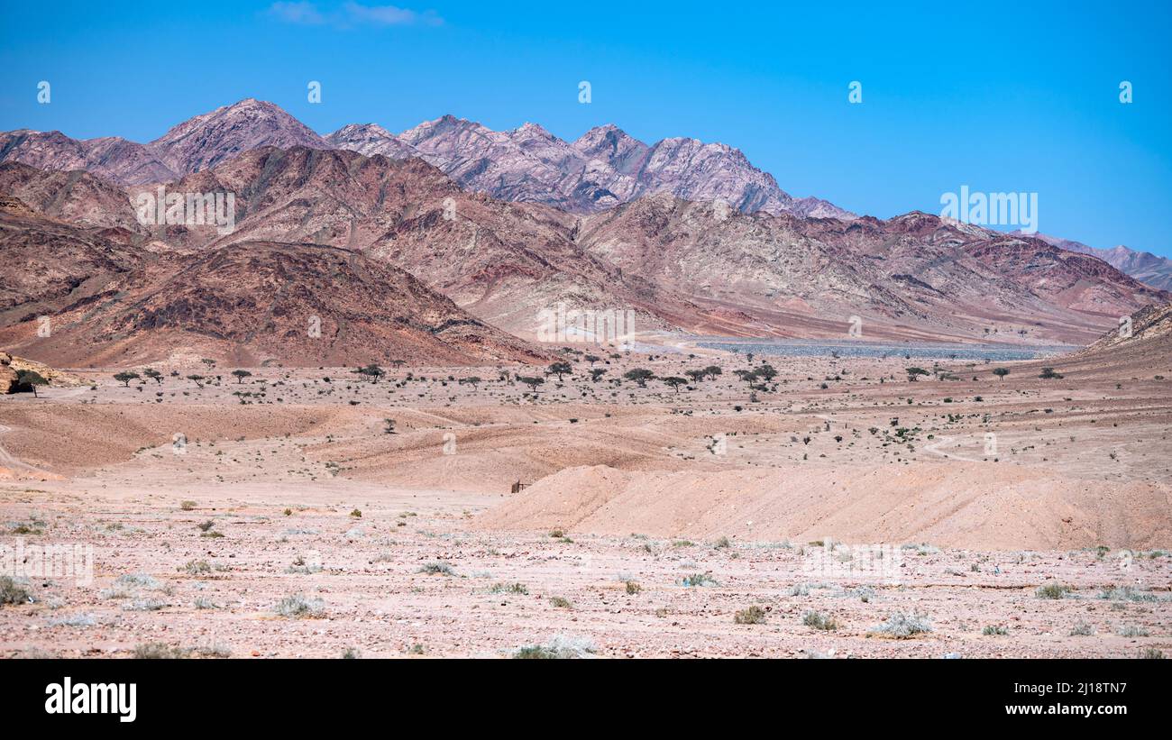 Berge zwischen der Stadt Aqaba und dem Wadi Rum Schutzgebiet nahe der jordanisch-saudischen Grenze. Tutun, Jordanien. Stockfoto