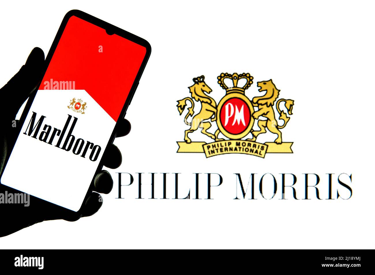 In dieser Abbildung ist ein Marlboro-Logo auf einem Smartphone mit einem Philip Morris International-Logo im Hintergrund zu sehen. Stockfoto