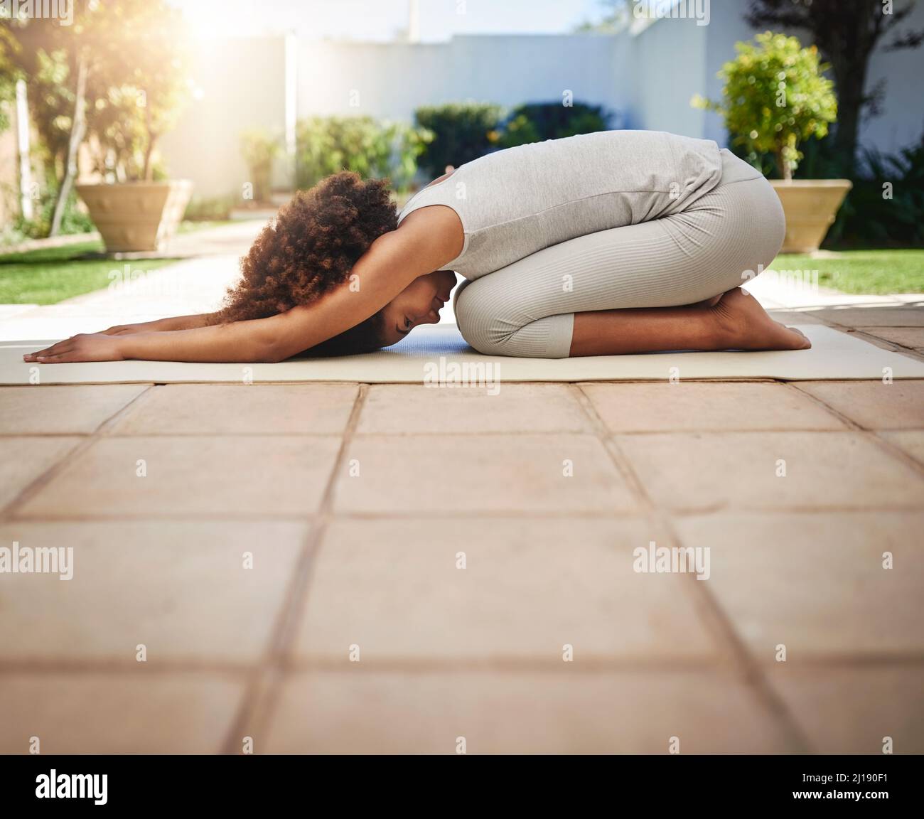 Fitter werden durch Yoga. Ganzkörperaufnahme einer sportlichen jungen Frau, die im Freien Yoga praktiziert. Stockfoto