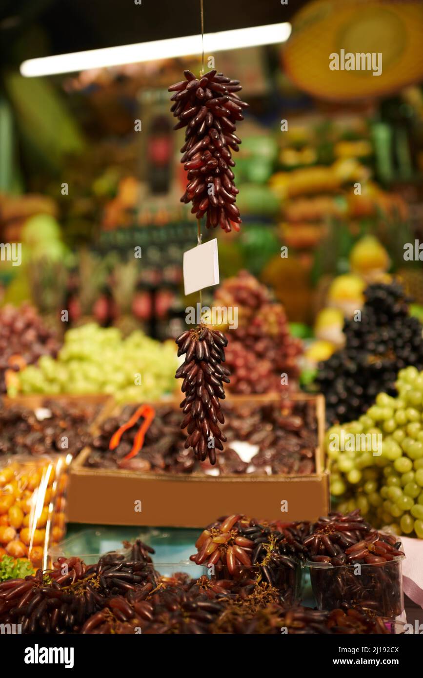 Trauben von köstlichen Trauben. Aufnahme von hängenden Trauben auf einem Markt. Stockfoto