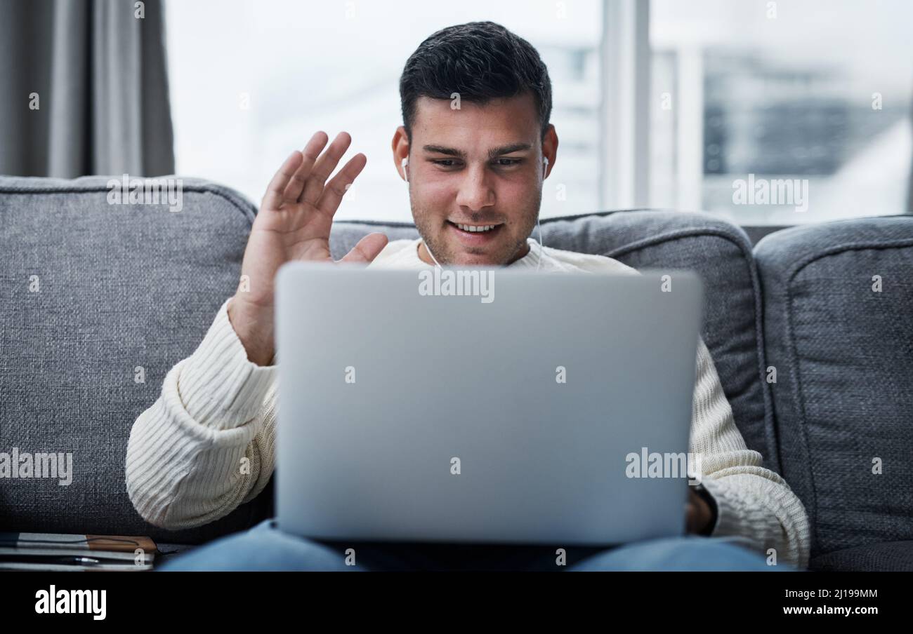 Holen Sie sich die Sicherheit und den Komfort von zu Hause. Aufnahme eines jungen Mannes, der einen Laptop benutzt, um einen Videoanruf zu tätigen, während er von zu Hause aus arbeitet. Stockfoto