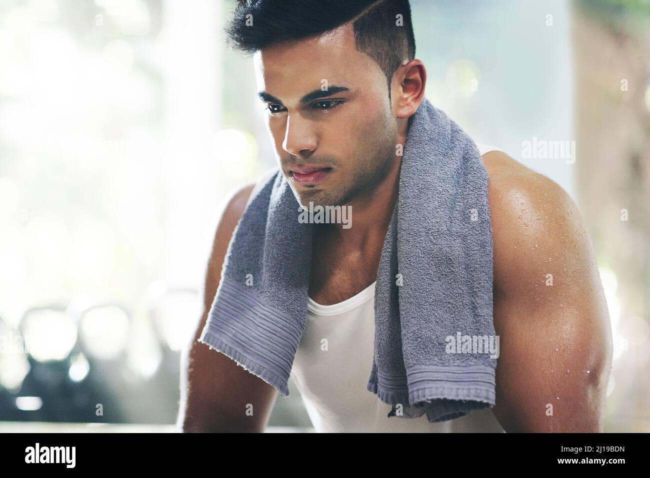 Ich bin jetzt zu weit gekommen, um aufzugeben. Eine kurze Aufnahme eines hübschen jungen Sportlers, der eine Pause vom Training im Fitnessstudio einnahm. Stockfoto