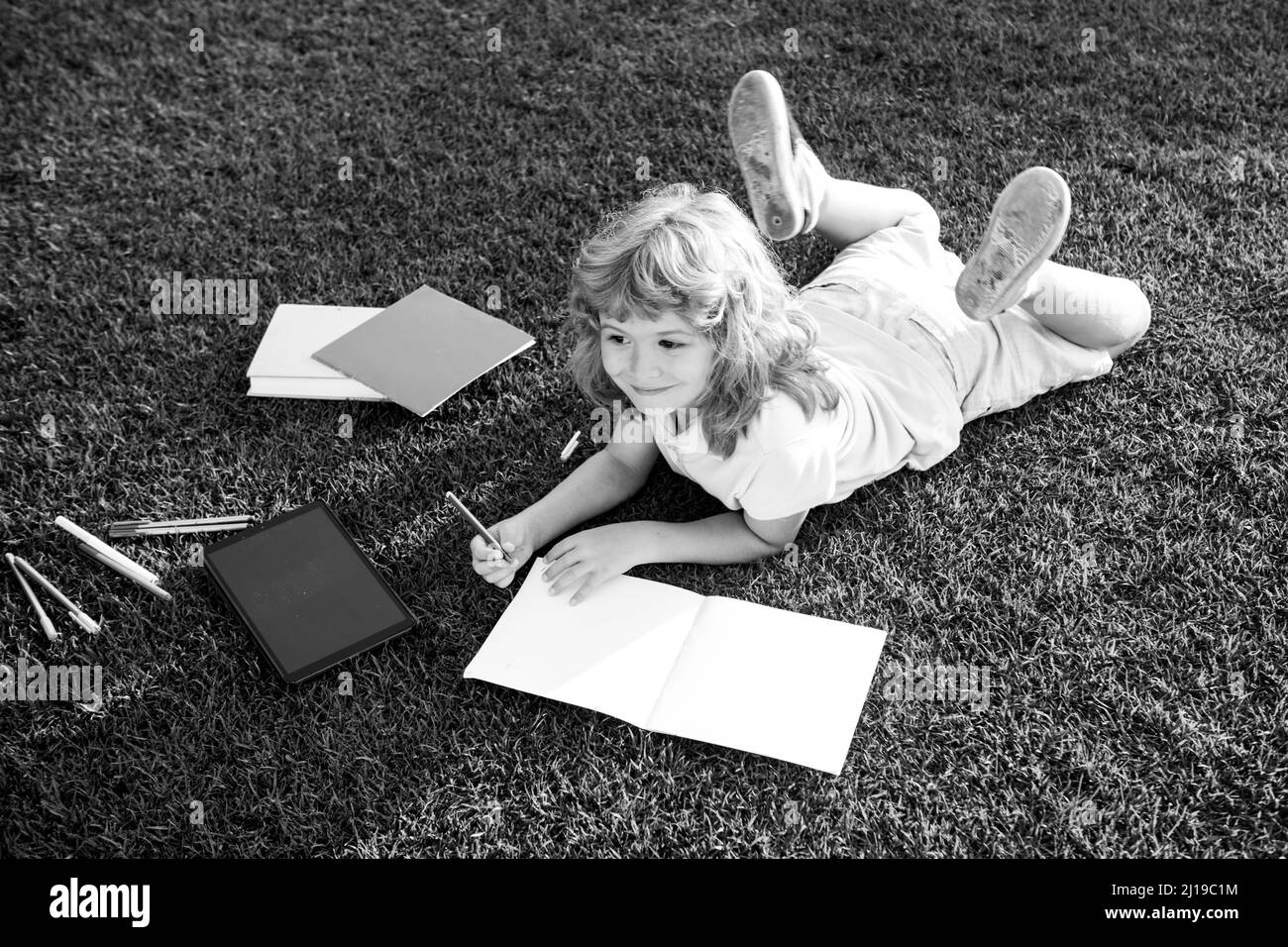 Kinderschule schreiben auf Notebook, Outdoor-Bildung. Natur und Park. Frühzeitiges Lernen. Sommer im Freien. Konzept der Kinder lernen, studieren, Schule und Stockfoto