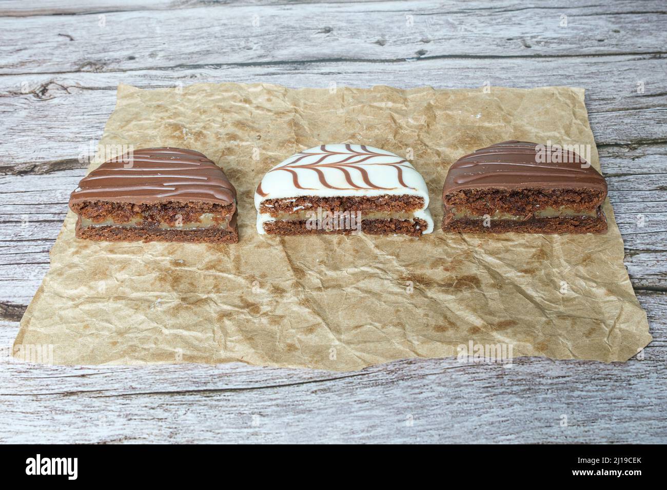 Drei Hälften brasilianischer Honigkuchen. Traditionell und mit weißer Schokolade überzogen, gefüllt mit Dulce de leche. Stockfoto