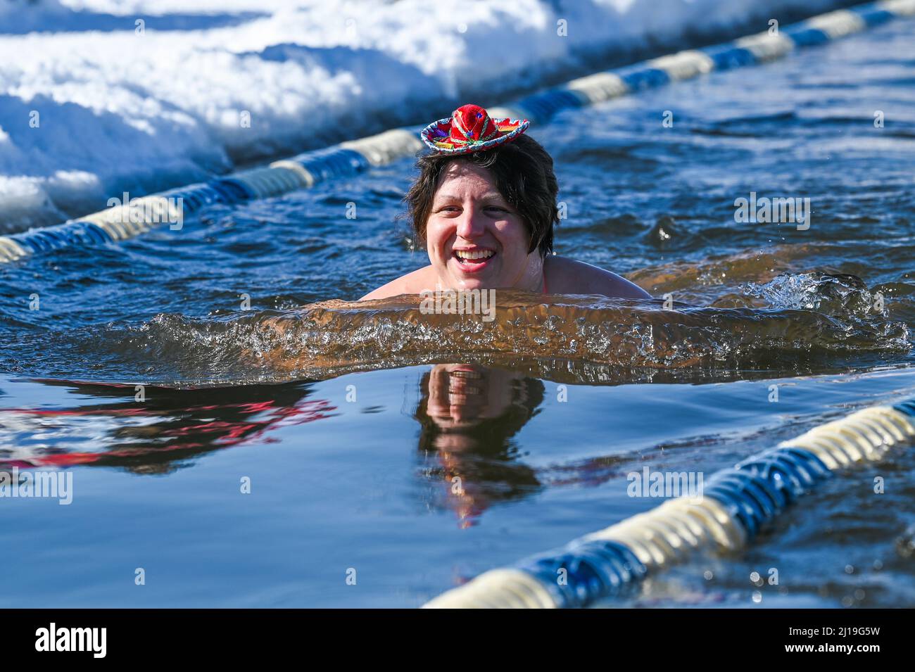 Kaltwasserschwimmer schwimmen im März im eisigen Wasser des Lake Memphremagog in der Nähe des kanadischen Boards in Newport, VT. Stockfoto