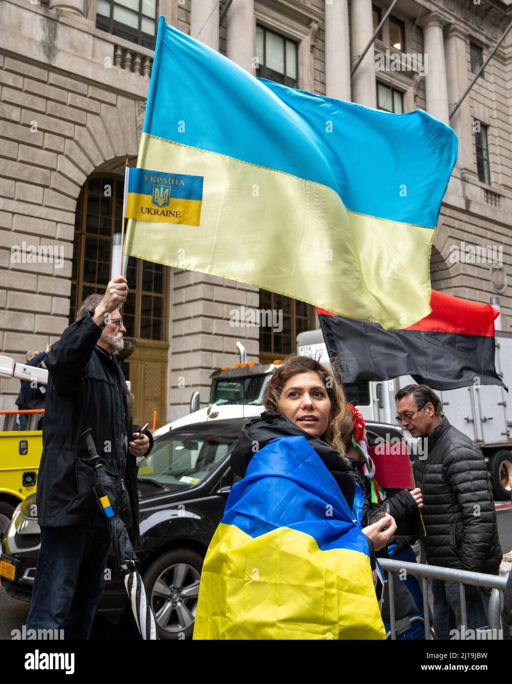 New York, USA. 23. März 2022. Ukrainische Anti-Kriegs-Demonstranten winken und tragen Flaggen während einer Unterstützungs-Show für die Ukraine gegen die russische Invasion. Der ukrainische Generalkonsul in New York, Oleksii Holubov und der Bürgermeister von New York, Eric Adams, hoben US- und ukrainische Flaggen im Finanzviertel von Manhattan auf. Kredit: Enrique Shore/Alamy Live Nachrichten Stockfoto