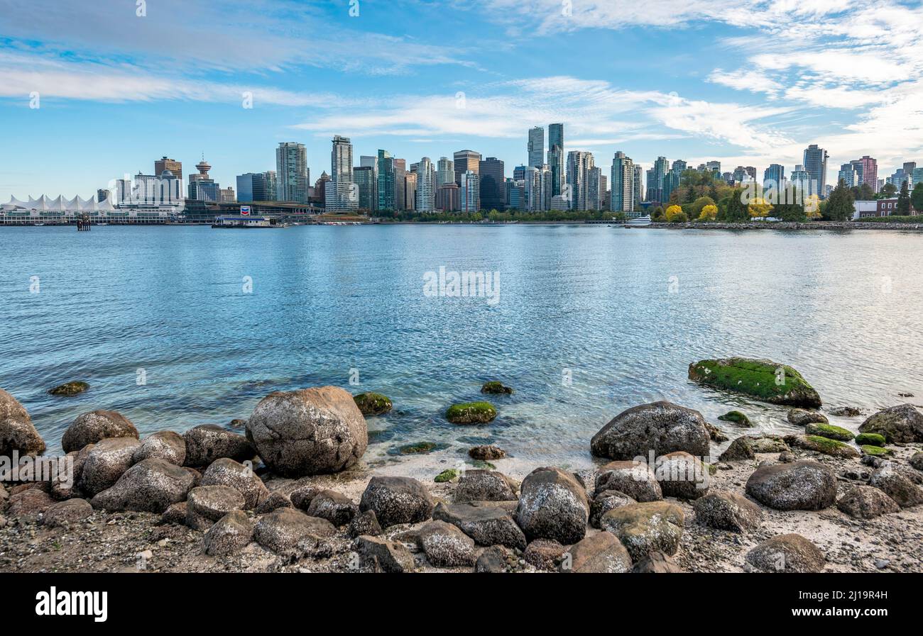 Steine an der Küste, Blick über das Meer von Hallelujah zeigen auf Skyline mit Wolkenkratzern, Stanley Park, Vancouver, British Columbia, Kanada Stockfoto