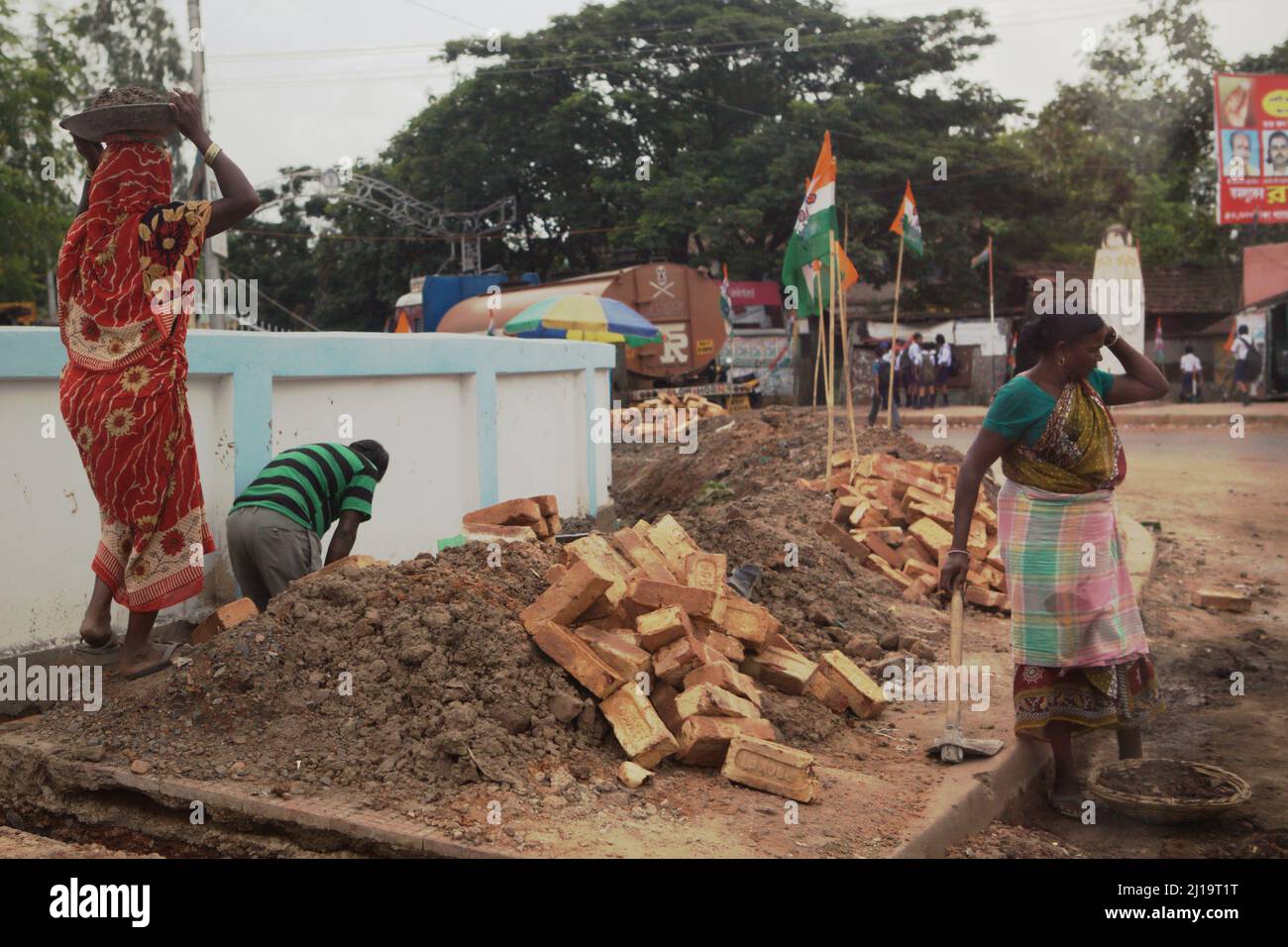 Frauen, die in Handarbeit auf einer Baustelle am Straßenrand in Kolaghat, Purba Medinipur, Westbengalen, Indien, arbeiten. Stockfoto