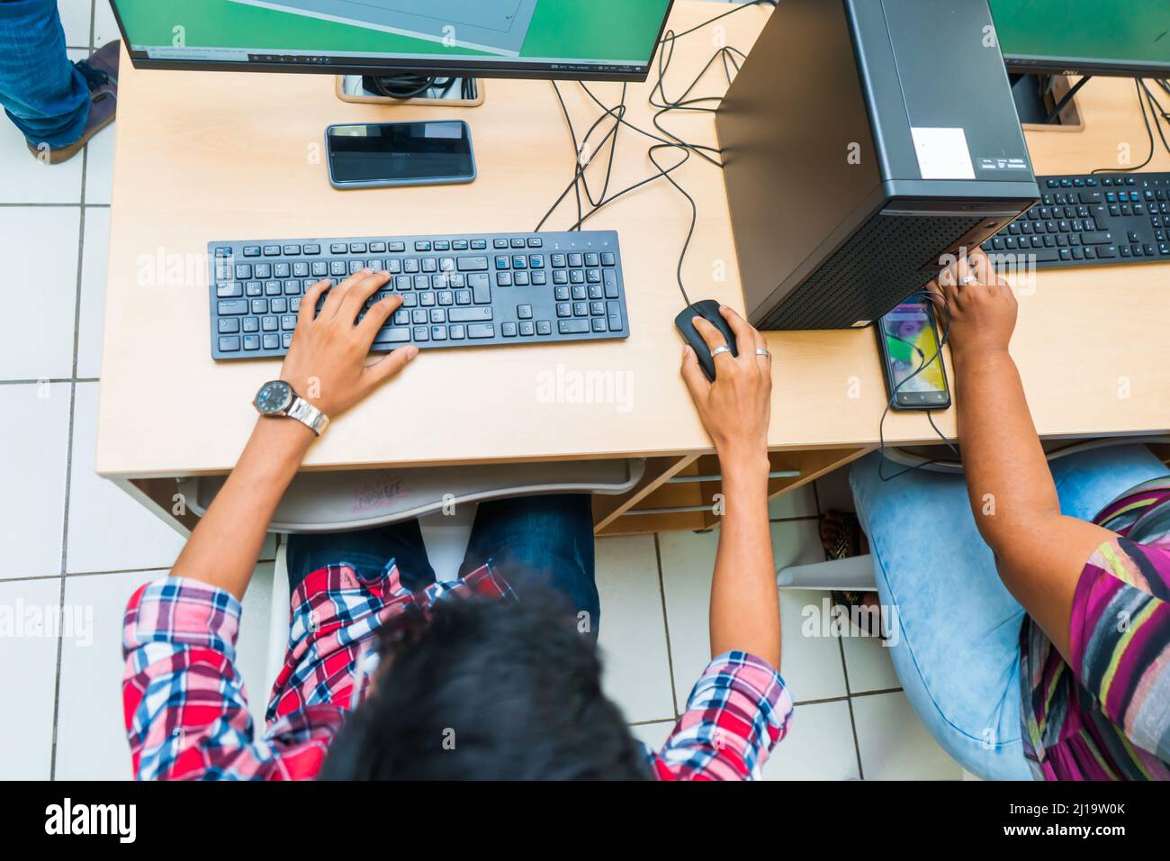 Draufsicht auf einen dunkelhäutigen mittelamerikanischen Studenten in der Brille für technische Bildung verwendet einen Desktop-Computer Stockfoto