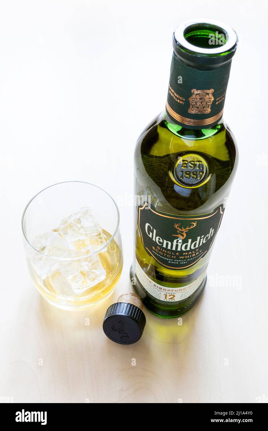 Moskau, Russland - 20. März 2022: Glas- und offene Flasche des 12 Jahre alten Glenfiddich Single Malt Scotch Whisky auf hellem Tisch. Die Glenfiddich Distillery Stockfoto