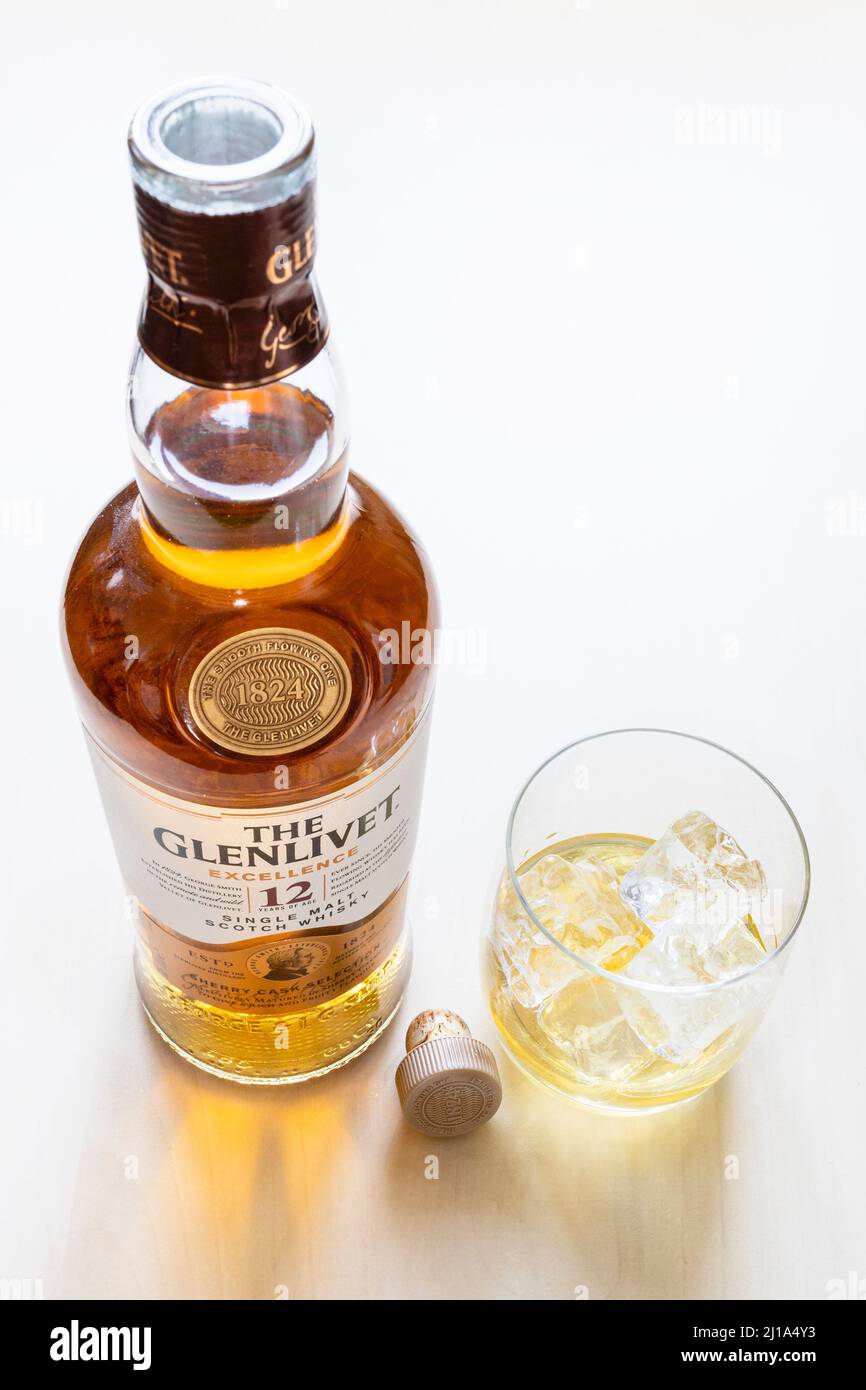 Moskau, Russland - 20. März 2022: Glas- und offene Flasche des 12 Jahre alten Glenlivet Single Malt Scotch Whisky auf hellem Tisch. Glenlivet Brennerei war fou Stockfoto