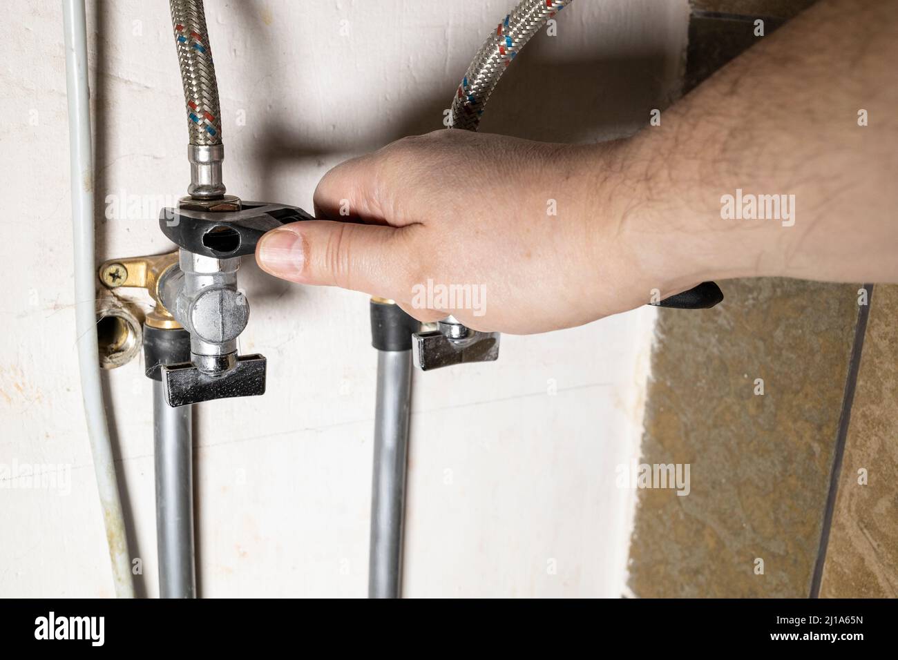 Klempner Hand installiert Wasser-Stopp-Hahn durch verstellbaren Schraubenschlüssel zu Hause Stockfoto