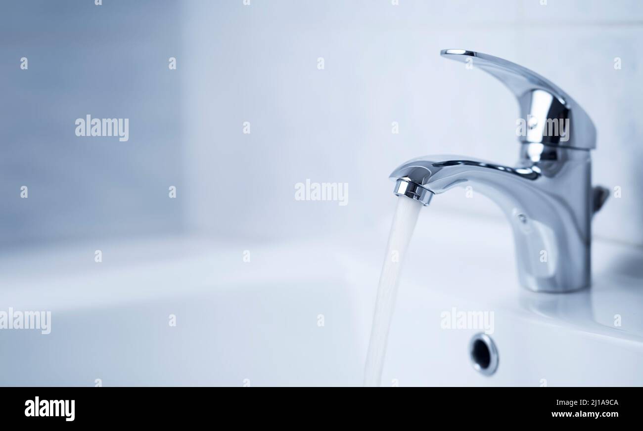 Wasserhahn, Wasserhahn aus Edelstahl. Im Badezimmer mit Waschbecken fließt Wasser. Modernes, sauberes Haus. Hygienekonzept. Stockfoto