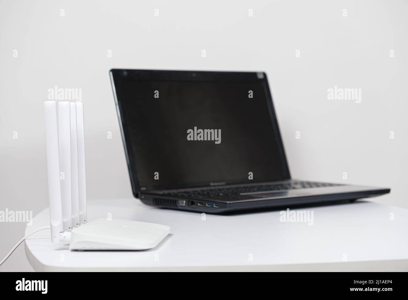 Laptop und wi-Fi-Router auf weißem Hintergrund. Internetverbindung. Stockfoto