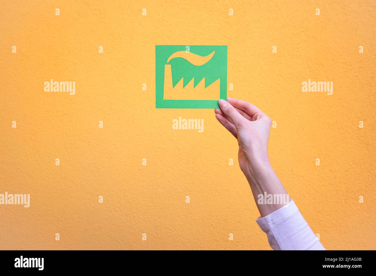 Die Hand hält das grüne Industriesymbol Stockfoto