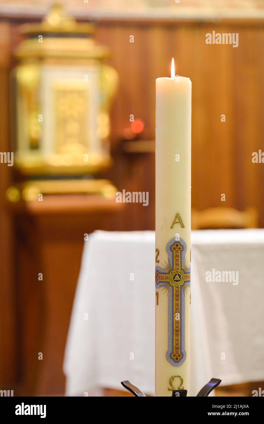 Vertikale Ansicht einer brennenden Kerze in einer Kirche Stockfoto