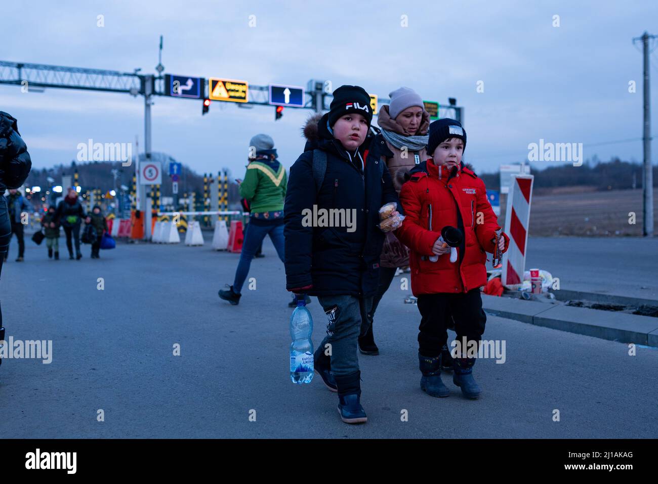 Kinder, die mit Koffern reisen, passieren einen Grenzübergang zwischen Polen und der Ukraine, während sie vor dem sich verschärfenden Krieg in der Ukraine, ihrem Land, fliehen Stockfoto