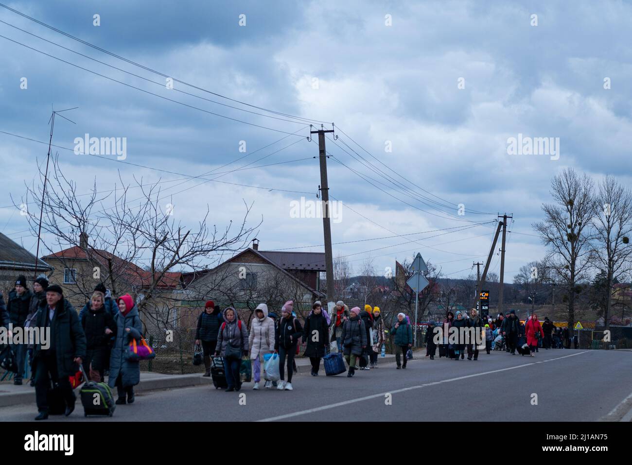 Am 6. März 2022 laufen die Menschen mit ihren Koffern zur Grenze zu Polen am Medyka-Grenzübergang in Sheyini, Ukraine. Mehr als 1,5 Millionen Stockfoto