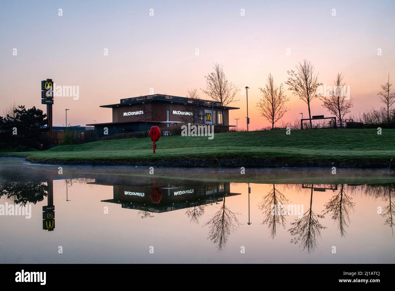McDonalds bei Sonnenaufgang. Lakeview Drive, Bicester, Oxfordshire, England Stockfoto