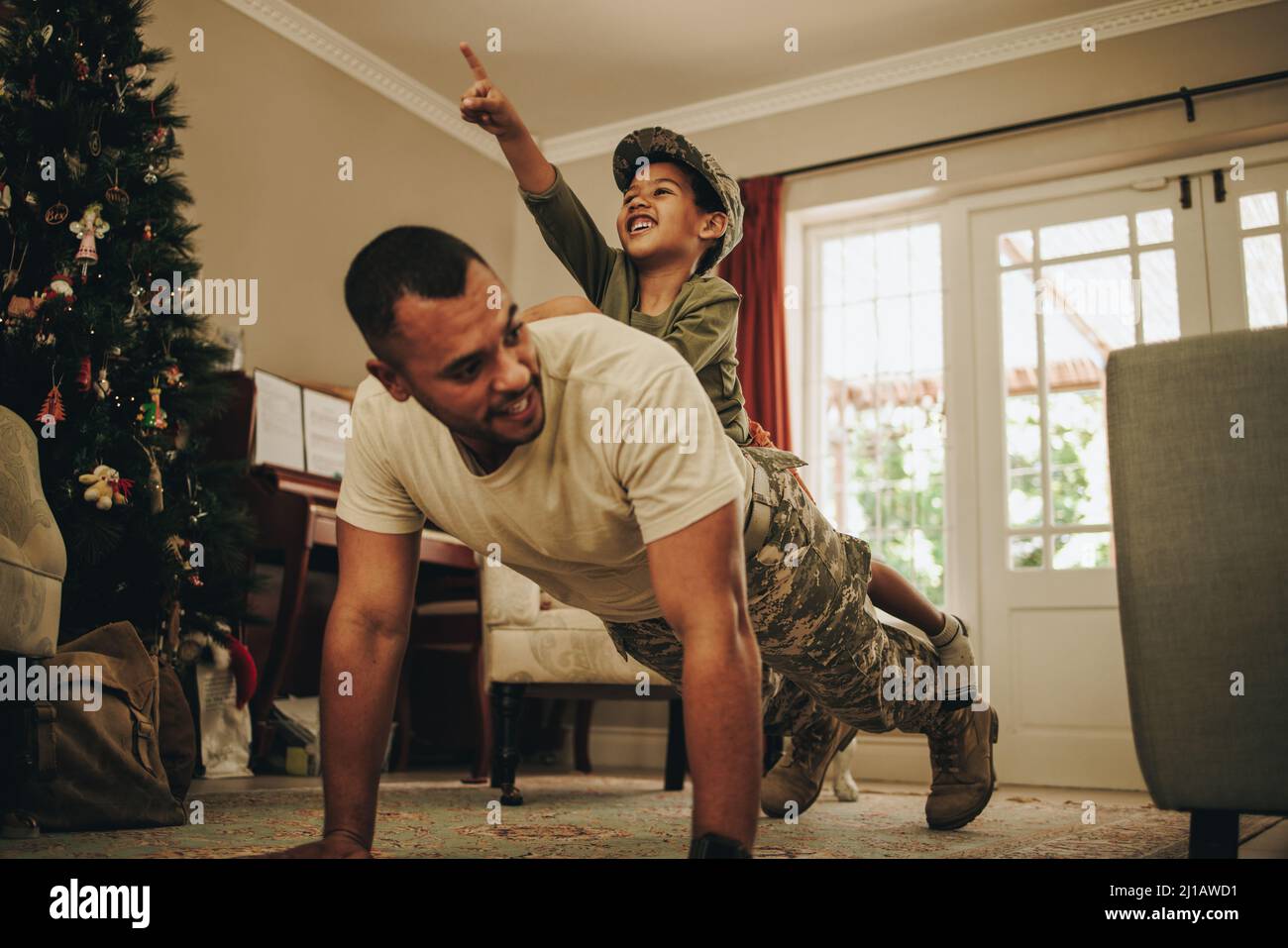 Militärvater, der sich zu Weihnachten mit seinem Sohn verbunden hat. Glücklicher Soldat der Armee verbringt die Ferien mit seinem Kind nach dem Einsatz. Vater und Sohn spielen Stockfoto