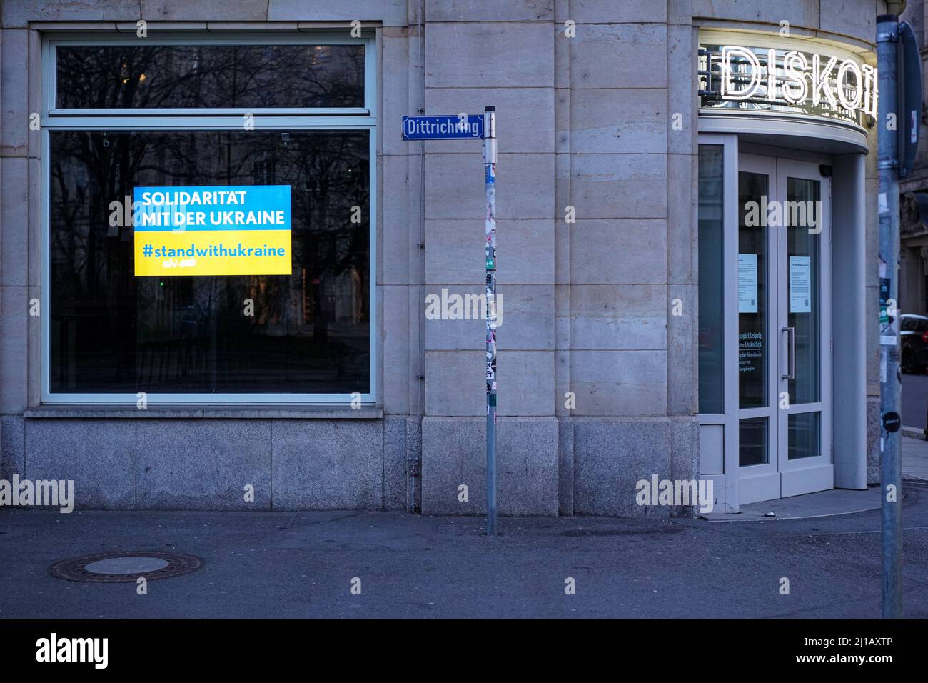 Eine Diskothek in Leipzig hat ein Schild mit der Aufschrift „Solidarität mit der Ukraine“ in ukrainischen Nationalfarben im Fenster. Stockfoto