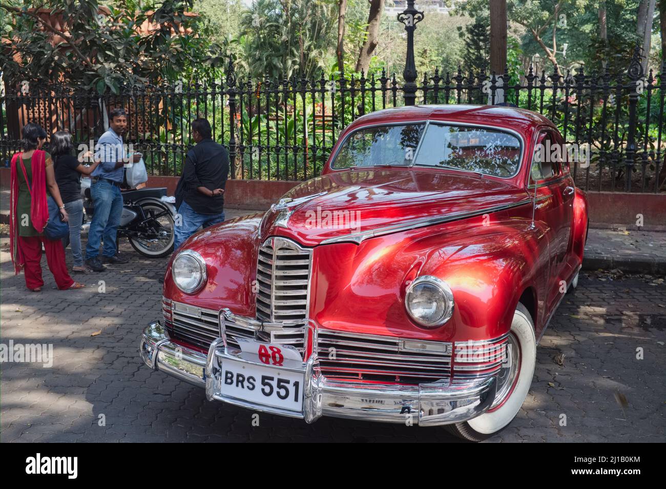 Während einer jährlich stattfindenden Oldtimer-Rallye in Mumbai (Bombay), Indien, wird am Endpunkt der Rallye, dem Horniman Circle, ein roter Oldtimer geparkt Stockfoto