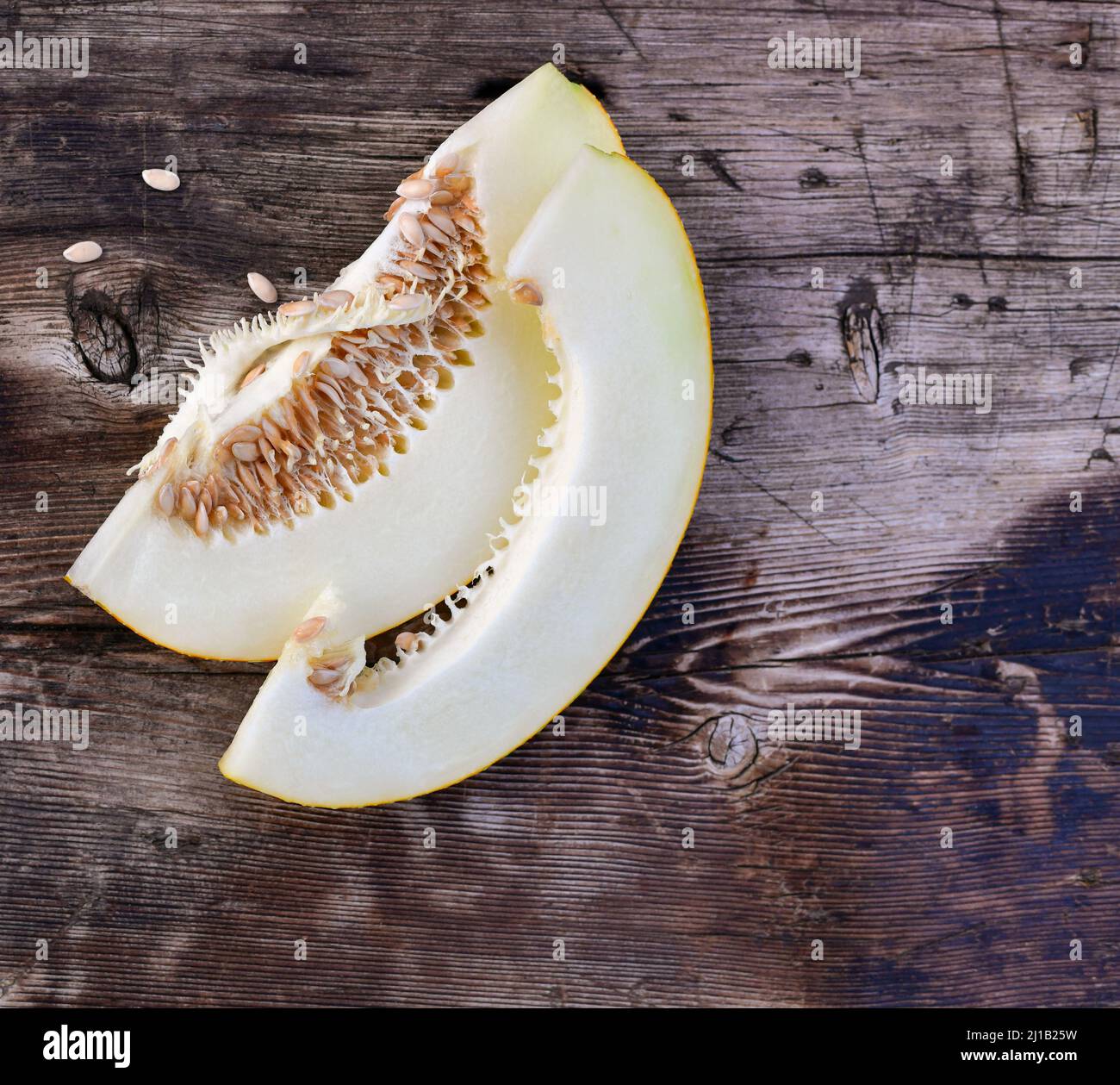 Scheiben reife Melone mit Samen innen auf einer Holzoberfläche. Stockfoto