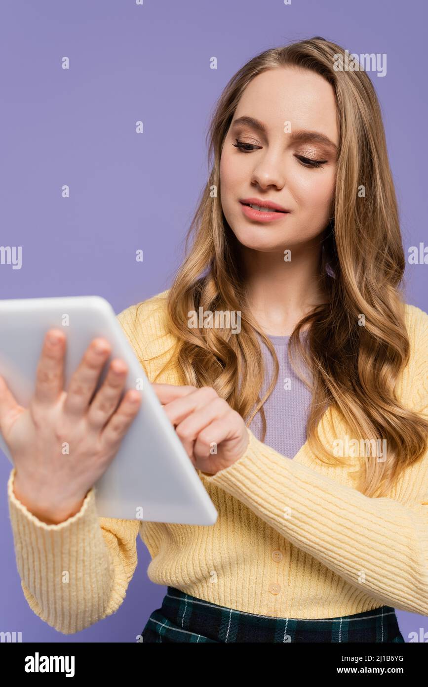 Junge Frau mit digitalen Tablet isoliert auf lila Stockfoto