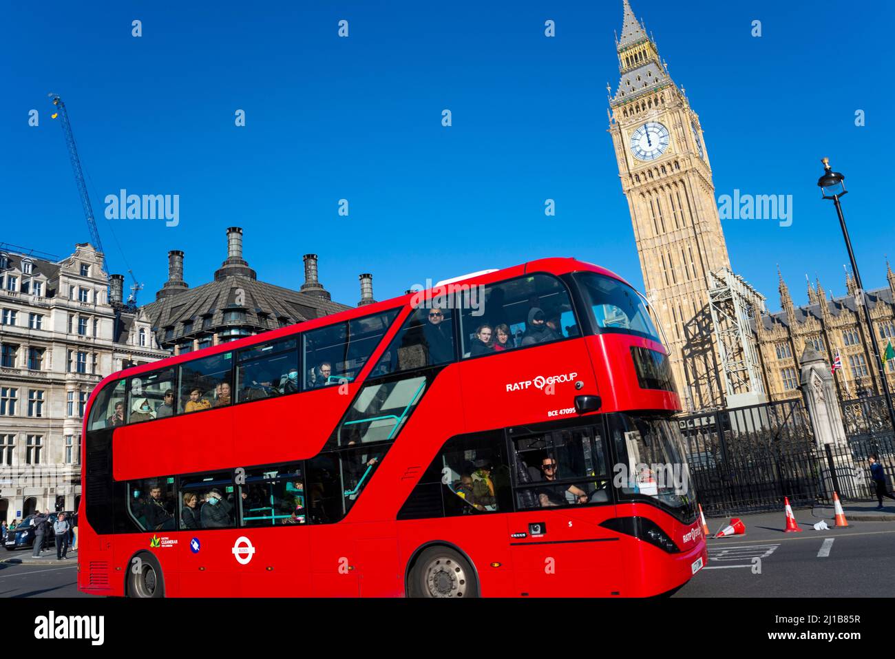 Kürzlich freigelegt restaurierter Elizabeth Tower, Big Ben, des Palace of Westminster, London, Großbritannien, mit einem roten Londoner Bus, der vorbeifährt. RATP-Gruppenbus Stockfoto