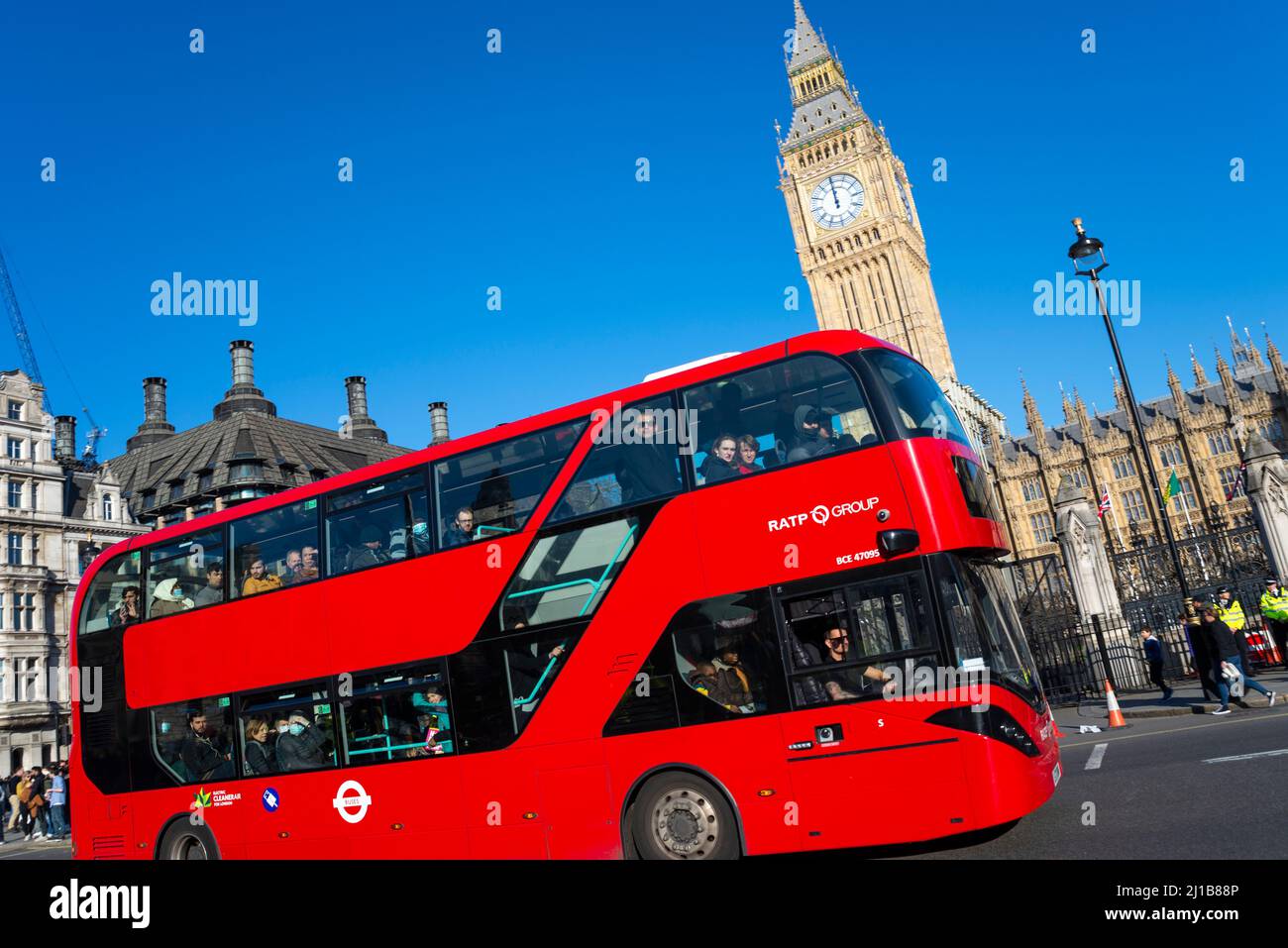 Kürzlich freigelegt restaurierter Elizabeth Tower, Big Ben, des Palace of Westminster, London, Großbritannien, mit einem roten Londoner Bus, der vorbeifährt. RATP-Gruppenbus Stockfoto