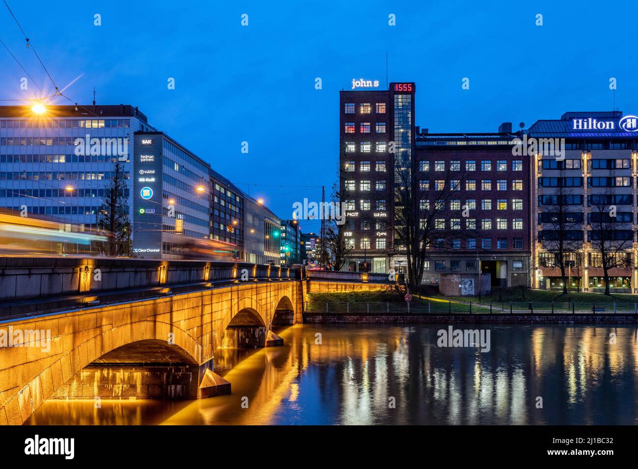 HILTON-HOTEL UND MODERNES GEBÄUDE BEI EINBRUCH DER DUNKELHEIT, AUFGENOMMEN VON DER LANGEN PITKASILTA-BRÜCKE, HELSINKI, FINNLAND, EUROPA Stockfoto