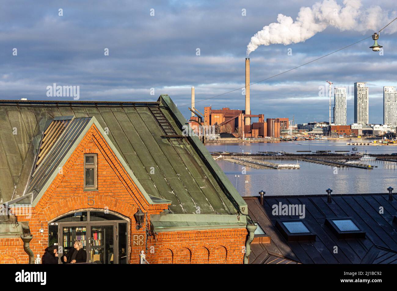 ANLEIHEAGENTUR VOR DEM KOHLEKRAFTWERK VON HANASAARI, MODERNES HOCHHAUS IM BAU IM HINTERGRUND, HELSINKI, FINNLAND, EUROPA Stockfoto