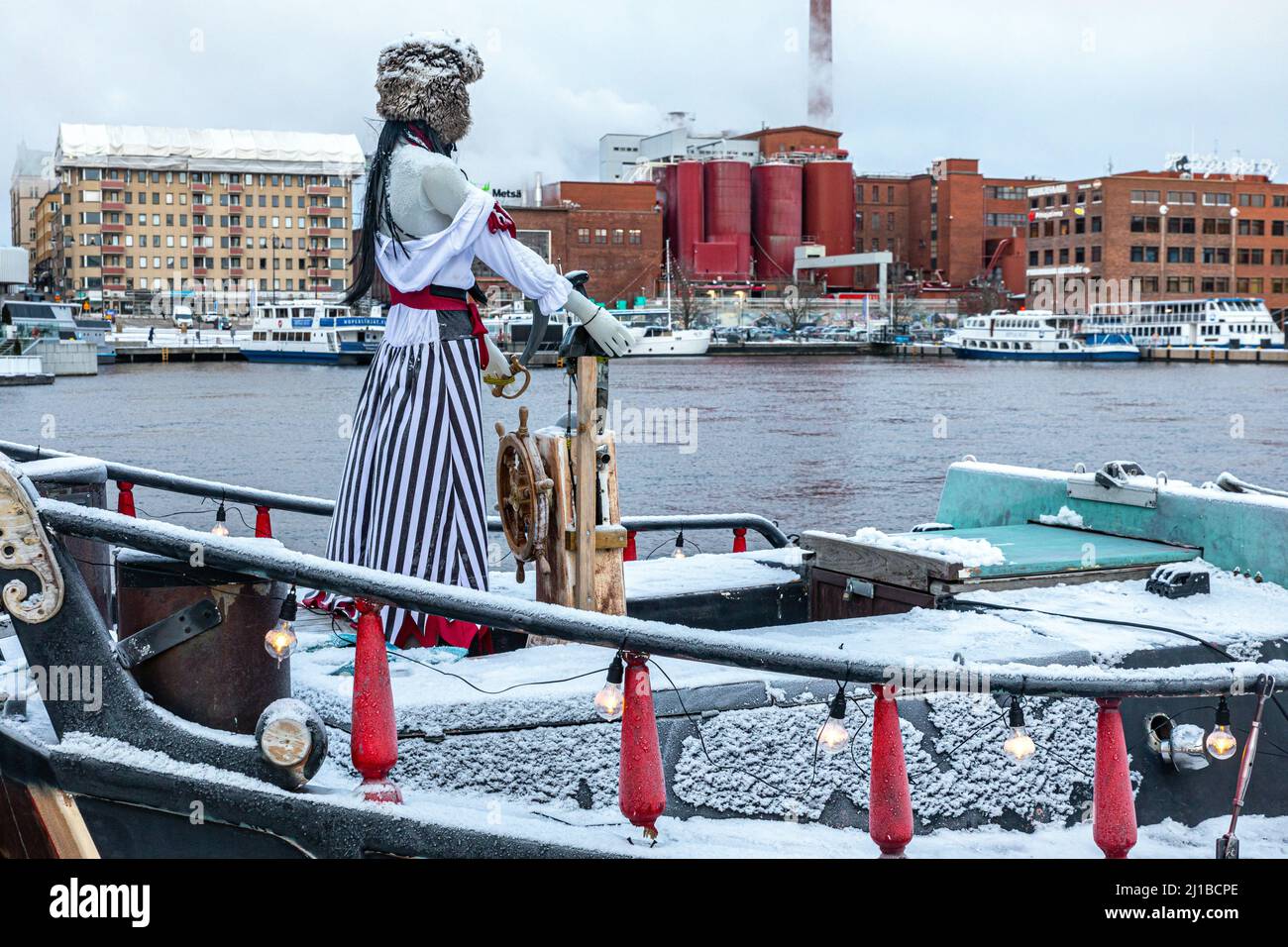 SCHAUFENSTERPUPPE AM STEUER EINES BOOTES VOR DER TAKO-KARTONFABRIK FÜR METSA-BOARDS AM UFER DES NASIJARVI-SEES IN TAMPERE, FINNLAND, EUROPA Stockfoto