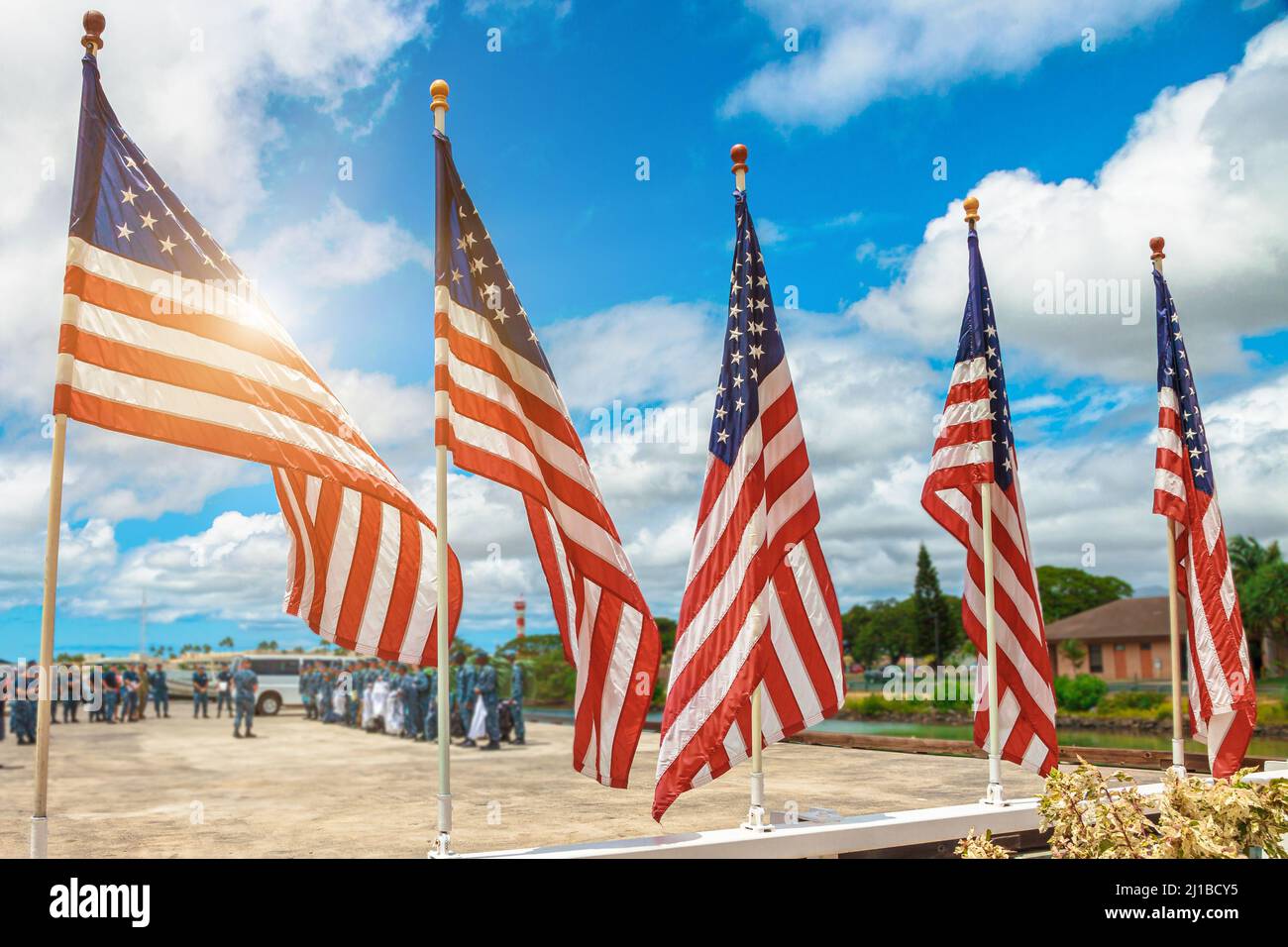 Amerikanische Flaggen mit Soldaten der amerikanischen Armee im Hintergrund. US-nationales patriotisches Konzept für den Unabhängigkeitstag und die Feiertagsfeier am 4.. Juli. Stockfoto