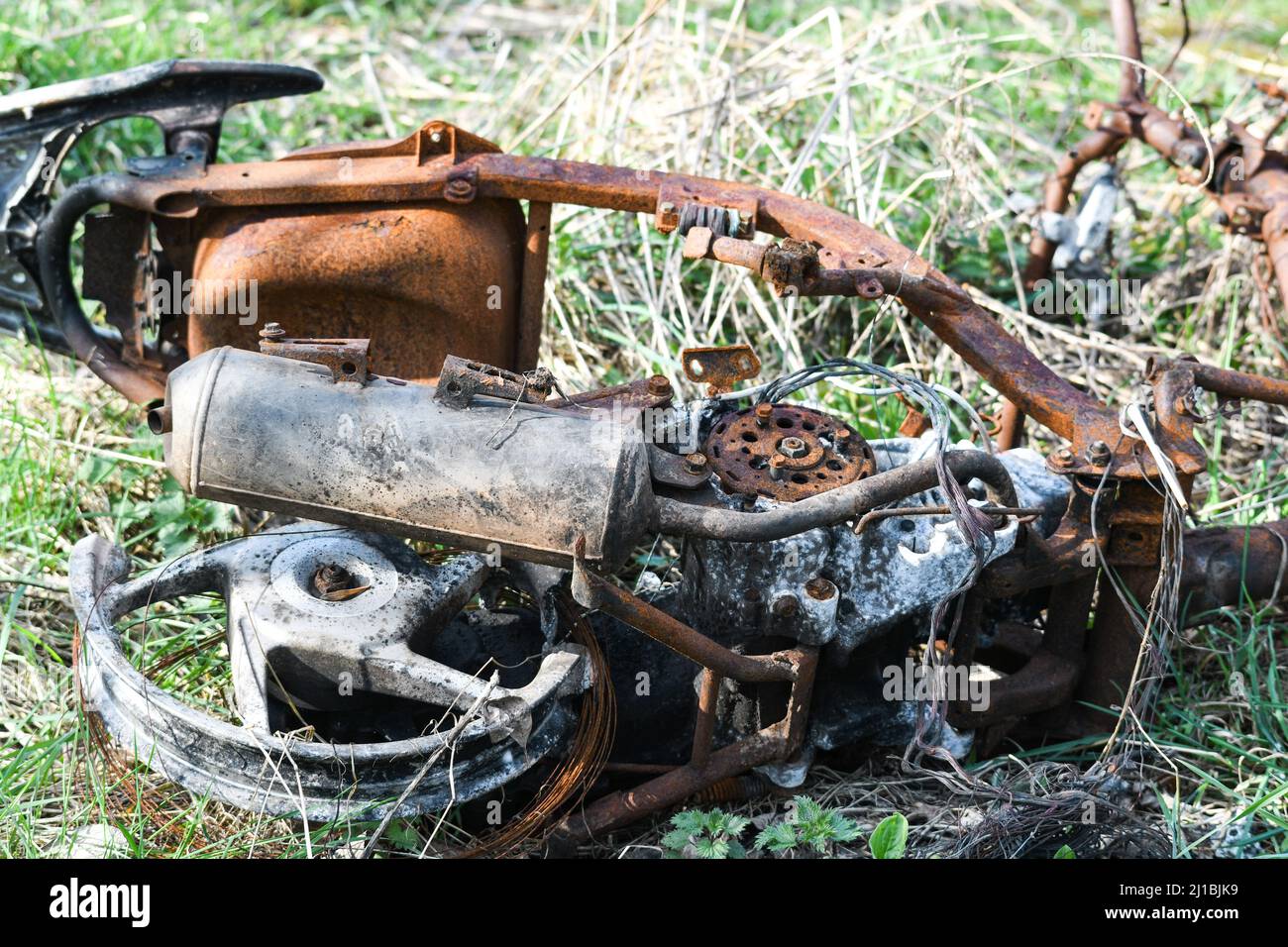 Ausgebranntes Moped auf einem Feld abgekippt Stockfoto