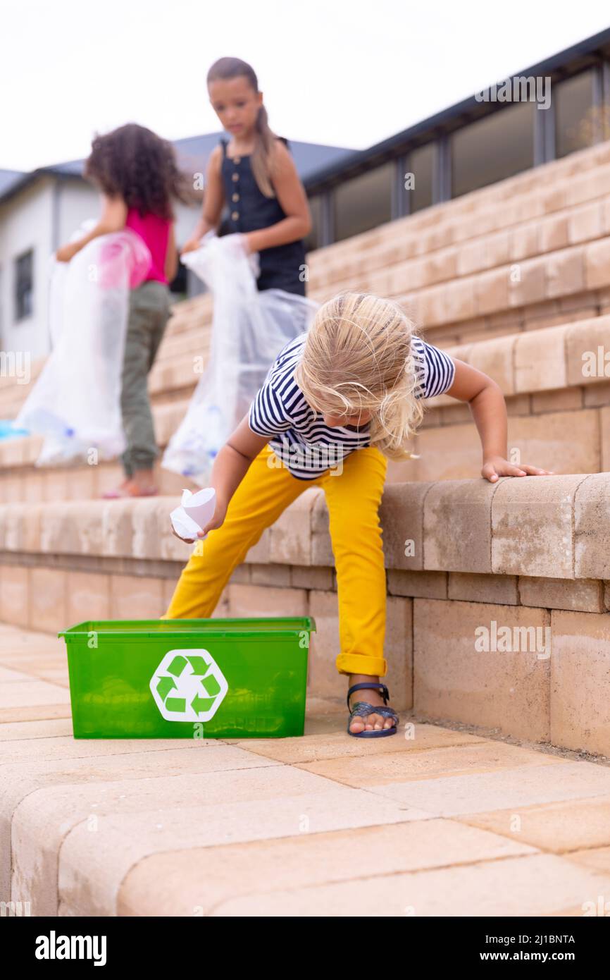 Multirassische Grundschüler sammeln Plastikmüll auf Schulbaustufen Stockfoto