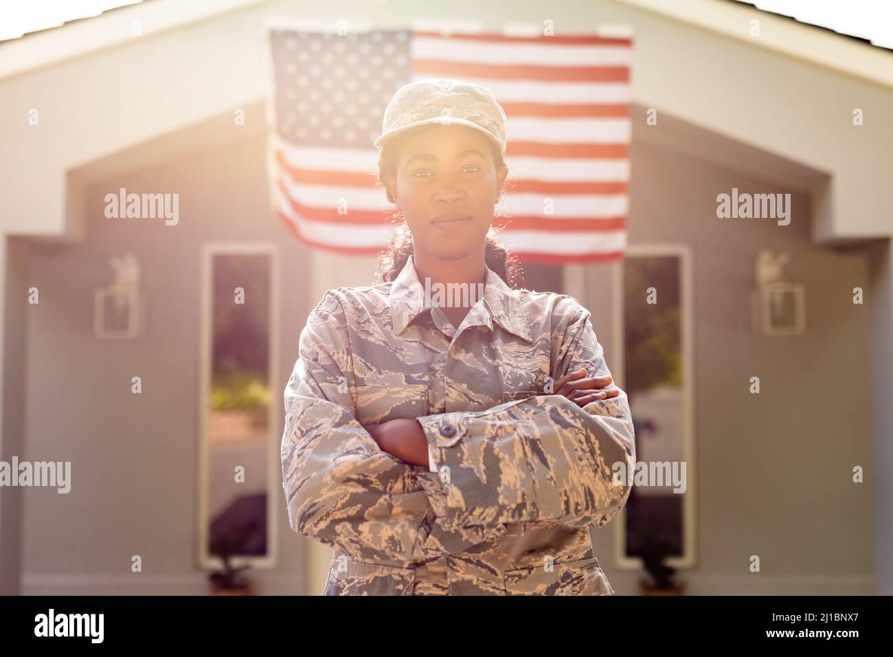Porträt eines selbstbewussten weiblichen, mittleren erwachsenen afroamerikanischen Soldaten in Uniform, der vor dem Haus steht Stockfoto