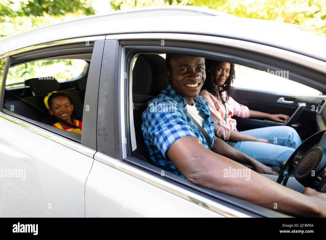 Porträt einer glücklichen afroamerikanischen Familie mit Sicherheitsgurten, die zusammen im Auto unterwegs sind Stockfoto