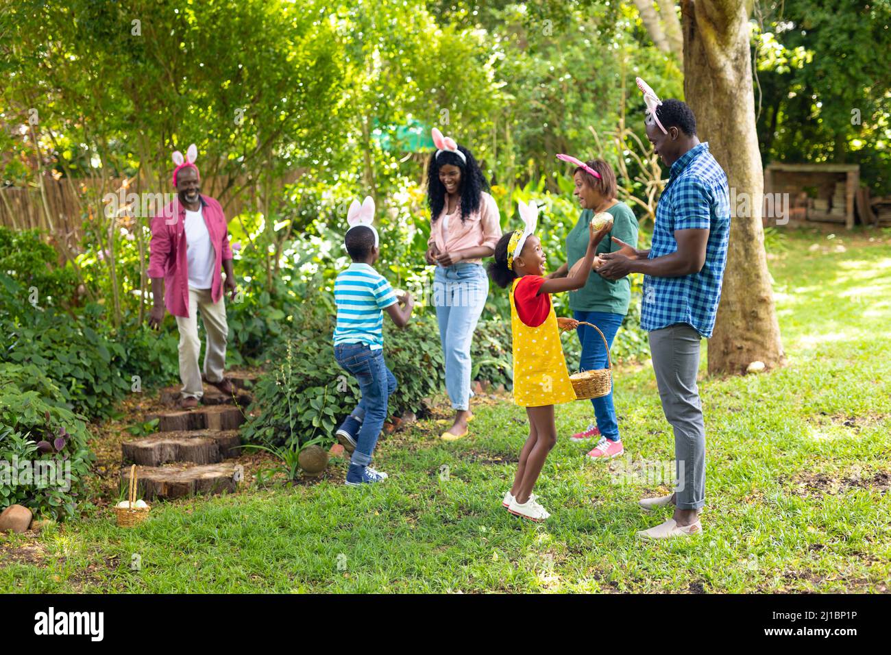 afroamerikanische Familie mit mehreren Generationen in Hasenohren mit ostereiern im Hinterhof Stockfoto