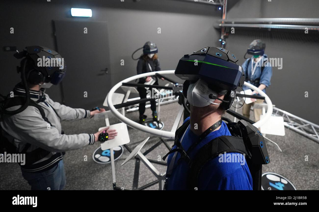 24. März 2022, Hamburg: Medienvertreter und Besucher stehen mit Rucksack und Helm sowie Hand- und Fußsensoren und Trackern in der neuen Virtual-Reality-Attraktion 'Yullbe' (Abkürzung für 'You will Be'/'Du wirst sein') im Miniatur Wunderland. Ab dem 1. April können sich Besucher der „Yullbe Wunderland“ als digitale kleine Menschen auf eine virtuelle Tour durch die Miniatur-Erlebniswelt begeben. Mit einer Virtual-Reality-Brille oder einem entsprechenden Helm auf dem Kopf werden Besucher der „Yullbe“-Welt zu Bewohnern des Miniatur Wunderlands und können den Wilden Westen, Venedig oder andere Welten V entdecken Stockfoto