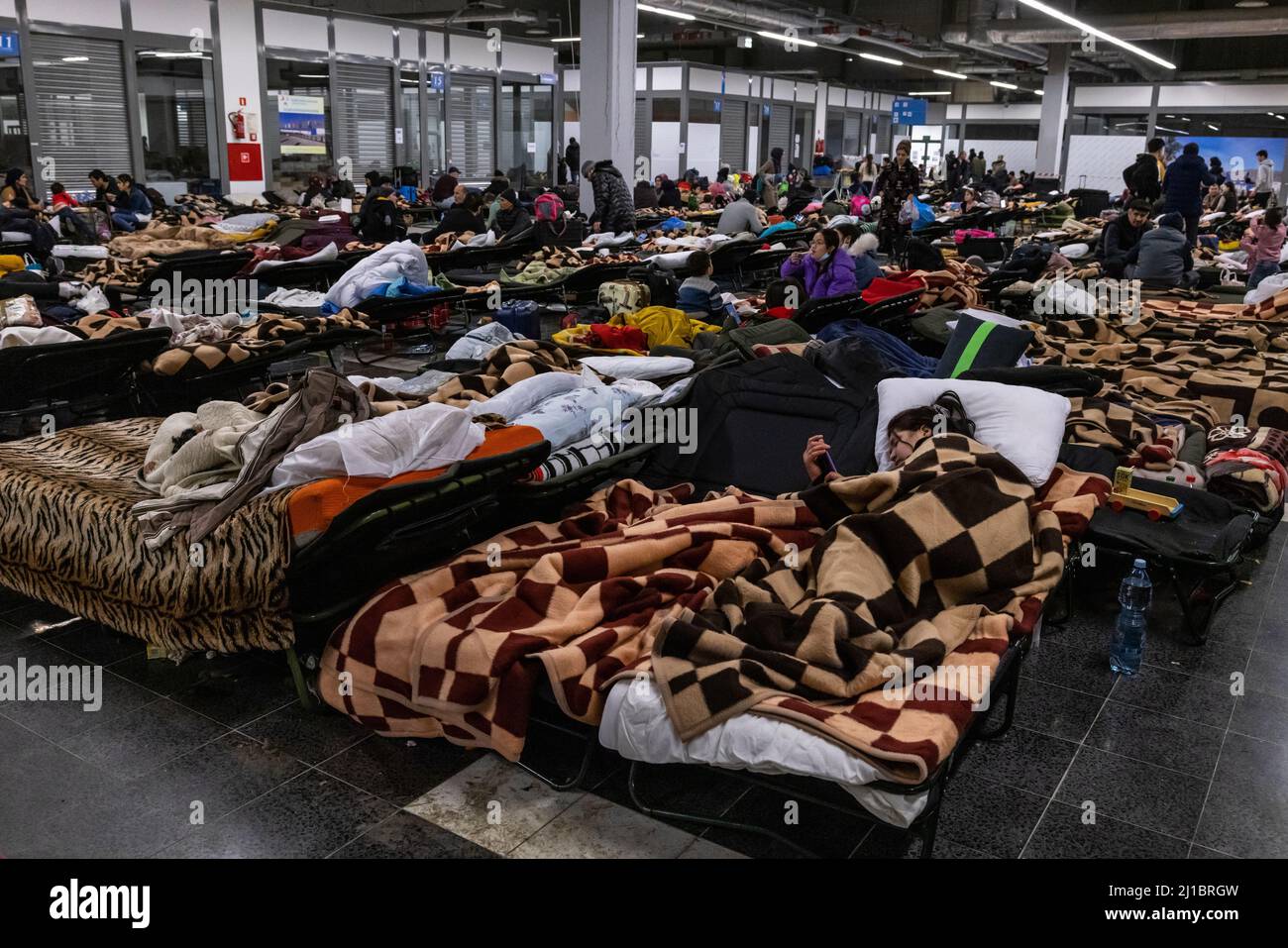 Flüchtlinge aus der Ukraine haben die zentrale Flüchtlingssammelstelle in einem Logistikzentrum in der Nähe von Korczowa im polnisch-ukrainischen Grenzgebiet erreicht. Hier können sie sich auf den zur Verfügung gestellten Babybetten ausruhen. Hier werden sie auch mit Lebensmitteln und Kleidung versorgt und dann per Bus weiter in andere Städte transportiert. Stockfoto