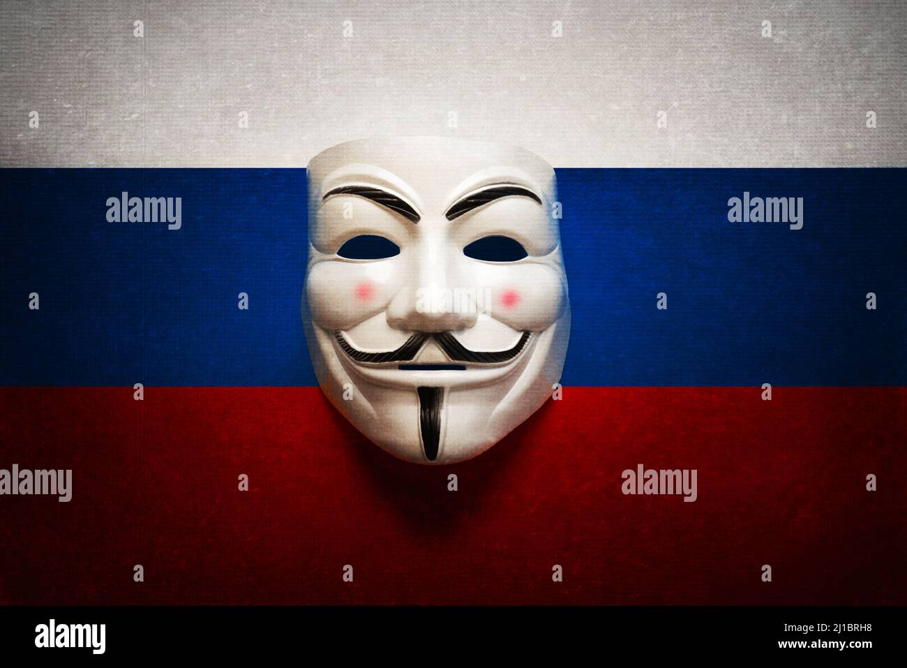 Hacker-Maske auf einem Computerbildschirm mit dem Hintergrund der russischen Flagge. Cyberangriffskonzept Stockfoto