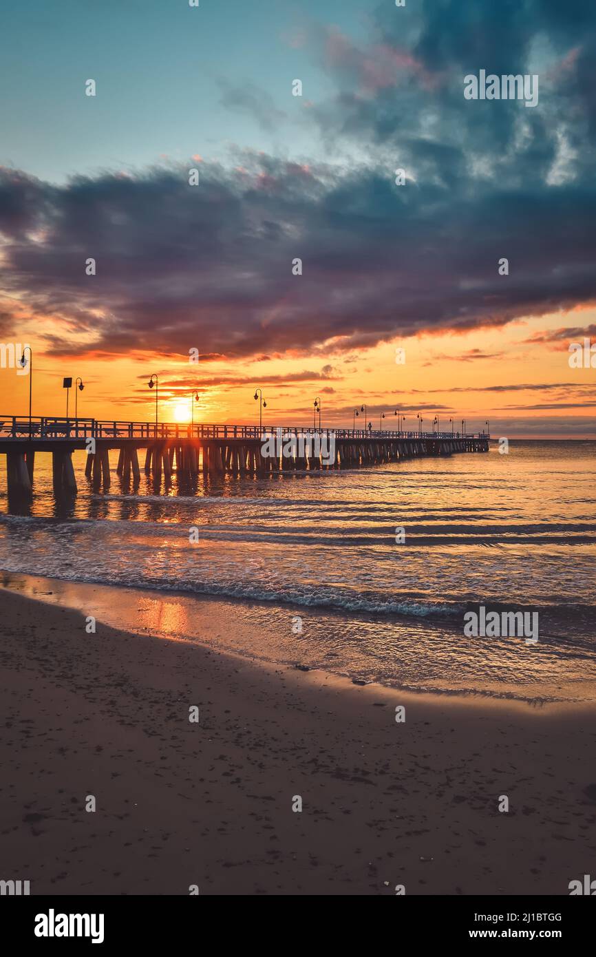 Farbenfrohe Morgenlandschaft am Meer. Hölzerner Pier am Meer bei Sonnenaufgang. Stockfoto